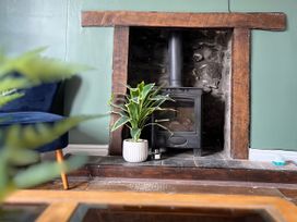 A living room with a wood stove and plant at Clarence House in Llandudno