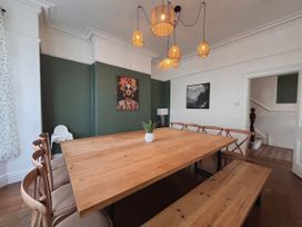 A dining room with a wooden table and chairs at Clarence House in Llandudno