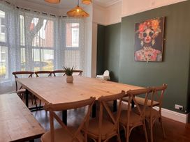 A dining room with a large table and chairs at Clarence House in Llandudno