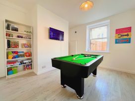 A snug with a pool table and games on shelves at Clarence House in Llandudno