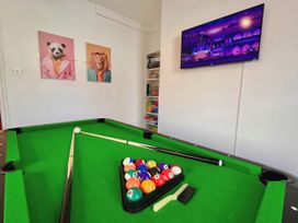 A game room with a pool table and television at Clarence House in Llandudno