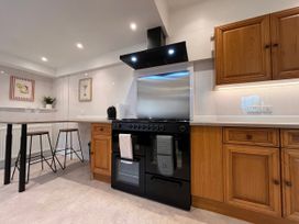 A kitchen with a stove and cabinets at Clarence House Llandudno