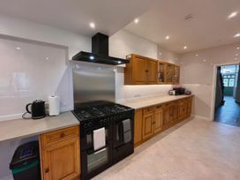 A kitchen with wooden cabinets and a stove at Clarence House in Llandudno