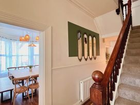 A hallway with a staircase and mirrors at Clarence House in Llandudno