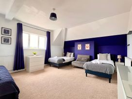 A bedroom with two beds and a dresser at Clarence House in Llandudno