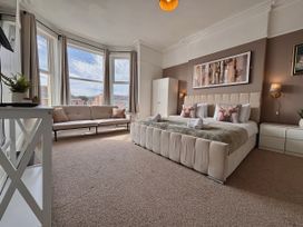 A bedroom with a bed and sofa at Clarence House in Llandudno