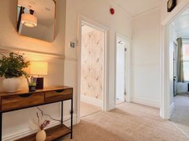 A hallway with a console table and lamp at Clarence House in Llandudno