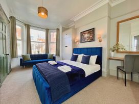A bedroom with a bed and sofa at Clarence House in Llandudno