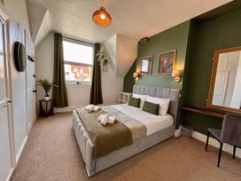 A bedroom with a bed and furniture at Clarence House in Llandudno
