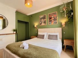 A bedroom with a bed and wall art at Clarence House in Llandudno