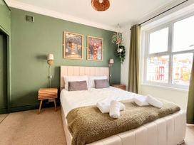 A bedroom with a bed and side tables at Clarence House in Llandudno
