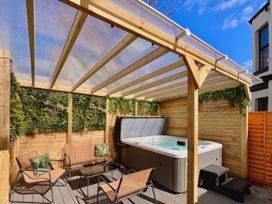 An outdoor area with a hot tub and seating at Clarence House in Llandudno
