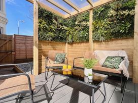 A garden seating area with a green wall and a coffee table at Clarence House in Llandudno