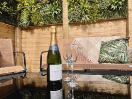 A bottle of sparkling wine and glasses on a table in an outdoor seating area at Clarence House in Llandudno