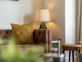 A living room with a couch and lamp at Clarence House in Llandudno