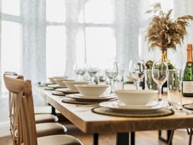 A dining room with a set table and champagne bottle at Clarence House in Llandudno