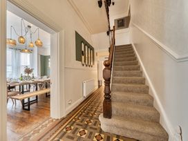 A hallway with stairs and access to dining area at Clarence House Llandudno