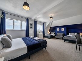 A bedroom with two beds and windows at Clarence House in Llandudno
