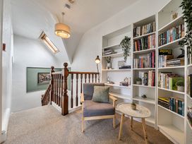 A hallway with a staircase and bookshelves at Clarence House in Llandudno