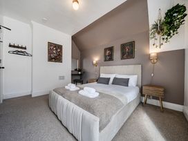 A bedroom with a bed and wall art at Clarence House Llandudno