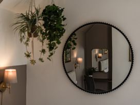 A living room with a mirror and hanging plants at Clarence House in Llandudno