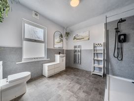 A bathroom with a toilet, sink and shower at Clarence House in Llandudno