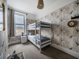A bedroom with a bunk bed and a bedside table at Clarence House in Llandudno