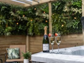 An outdoor space with a bottle of sparkling wine and glasses at Clarence House in Llandudno