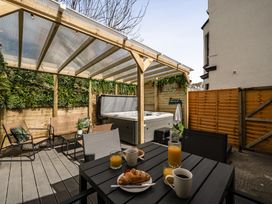 An outdoor seating area with a hot tub and breakfast items at Clarence House in Llandudno