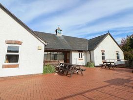An outdoor setting with benches and a clock on a building at Clwyd Special Riding Centre