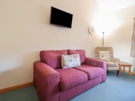 A living room with a sofa and television at Clwyd Special Riding Centre