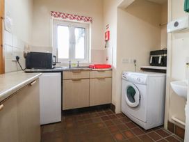 A kitchen with a sink, washing machine, and microwave at Clwyd Special Riding Centre