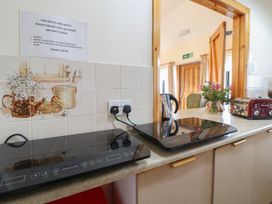 A kitchen with induction cooktops and a kettle at Clwyd Special Riding Centre
