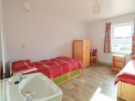 A bedroom with two beds and a sink at Clwyd Special Riding Centre