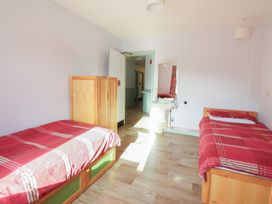 A bedroom with two beds and a sink at Clwyd Special Riding Centre 