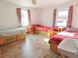 A bedroom with three beds and a window at Clwyd Special Riding Centre