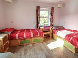 A bedroom with two beds and a desk at Clwyd Special Riding Centre