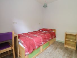 A bedroom with a bed and a shelf at Clwyd Special Riding Centre