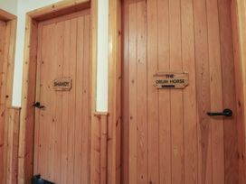 A hallway with two wooden doors labeled Shandy and The Drum Horse at Clwyd Special Riding Centre