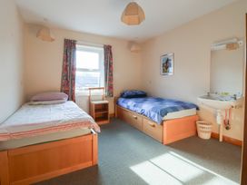 A bedroom with two beds and a wash basin at Clwyd Special Riding Centre