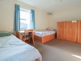 A bedroom with two beds and a desk at Clwyd Special Riding Centre