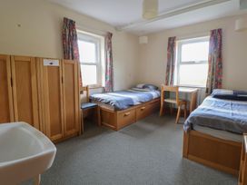 A bedroom with two beds and a table at Clwyd Special Riding Centre