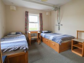 A bedroom with two beds and a table at Clwyd Special Riding Centre