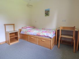 A bedroom with a bed, desk, and chair at Clwyd Special Riding Centre 