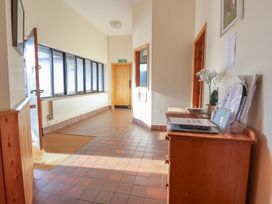 A hallway with a wooden console table and windows at Clwyd Special Riding Centre