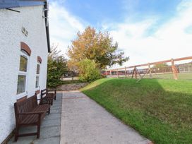 An outdoor area with benches and a fence at Clwyd Special Riding Centre
