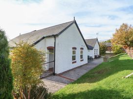 A building exterior with pathway and seating area at Clwyd Special Riding Centre