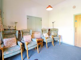 A sitting room with chairs and a small table at Clwyd Special Riding Centre in Llanfynydd