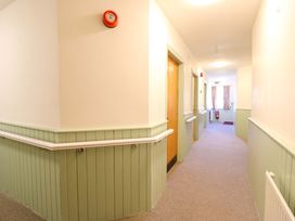A corridor with doors and windows at Clwyd Special Riding Centre in Llanfynydd