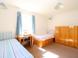 A bedroom with two beds and a chair at Clwyd Special Riding Centre in Llanfynydd